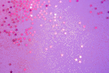 background of abstract pink and purple glittering stars on a purple background