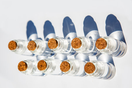 bottles of pink rose and blue essential oil transparent with a cork and with purple flower on a white background isolated, copy space for text. Spa beauty healthy lifestyle conceptの写真素材