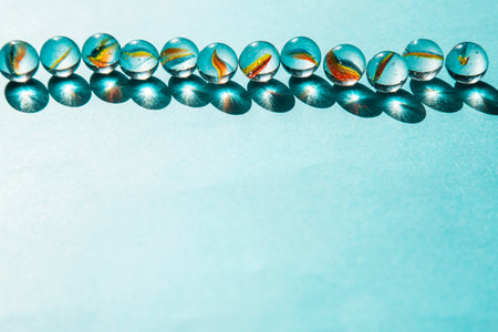 beautiful multicolored glass balls frame soft blue abstract background with copy space for textの写真素材