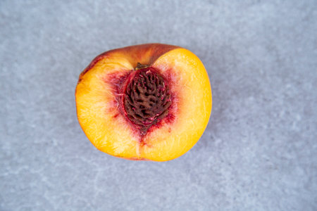 half of peach fruit on gray background, top view, copy space.の写真素材