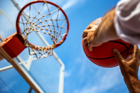 Basketball player in action. Close up of male hands holding basketball ball. Success, scoring,...