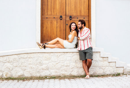 Young couple in love sitting on the steps of an old house.の写真素材