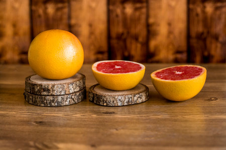 Grapefruit on a wooden background. Ripe red grapefruits on wooden podium on the wooden table.の写真素材