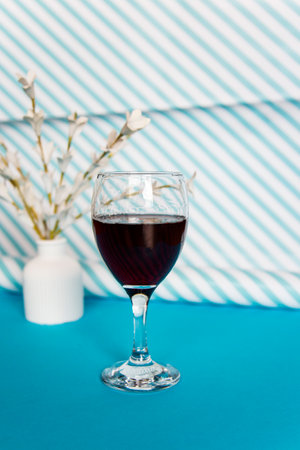 A glass of red wine on a blue background with a stripesの写真素材