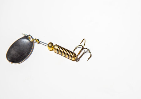 Fishing lure golden hook isolated on white background. Focus on the hook.