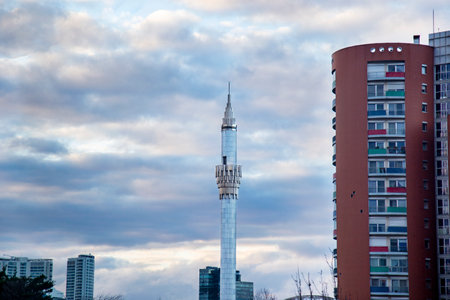 The minaret of the mosque and a residential building against sunset cloudy beautiful sky in the city Istanbulの写真素材