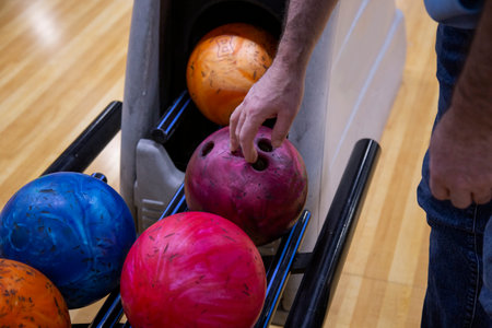 Close-up of a man's hand choosing bowling ball in a bowling club.の写真素材