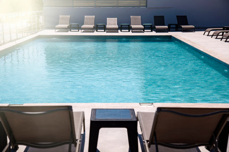 Swimming pool with sun loungers and deck chairs in luxury resortの写真素材