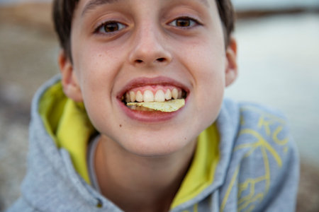 cute boy eating chips close-upの写真素材