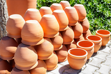Clay pots for plants on the street in the village. Handcrafted clean vases in a rowの写真素材