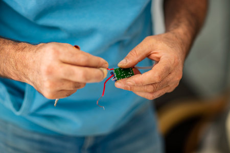 Close-up of a man's hands working with a voltage tester and electrical wires