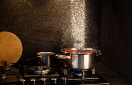 Cooking soup in a pot on a gas stove in the kitchenの写真素材