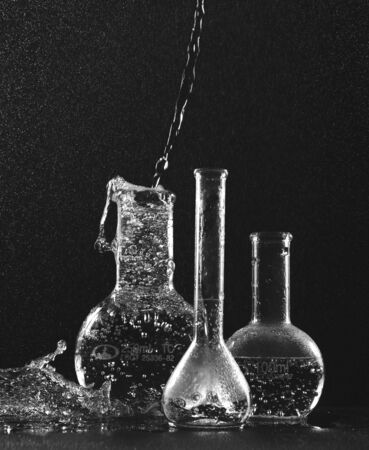 Transparent flasks with liquid on a black backgroundの写真素材