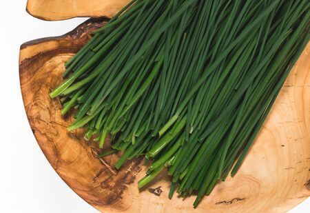 Fresh green onions on a wooden dishの写真素材