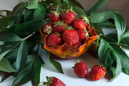 Ripe red strawberries. Berry in a orange vaseの写真素材