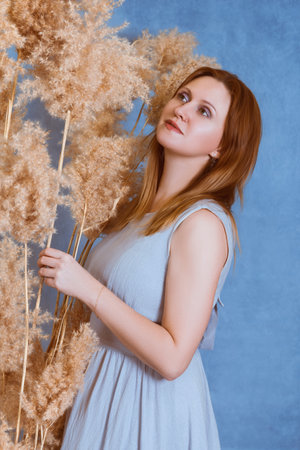 A girl on a blue background looks at the reedsの写真素材