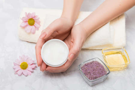 Care for women's hands with baths with sea salt and oil treatment. In the hands of a scrubの写真素材
