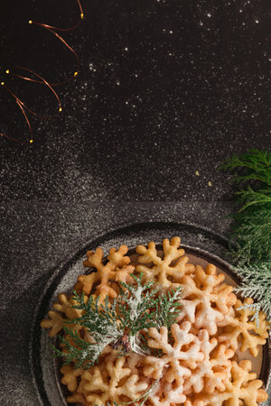 Firewood cookies in the form of snowflakes on a dark background in a Christmas decoration, top view, with copy spaceの写真素材