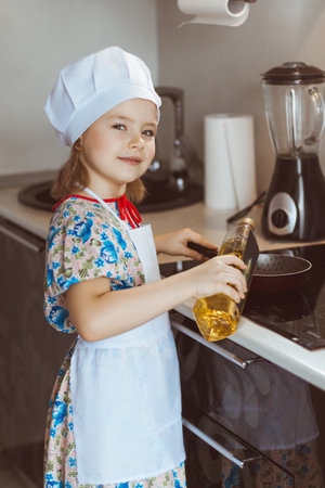 A girl cook cooks scrambled eggs. Stage one - pours sunflower oil. soft focusの写真素材