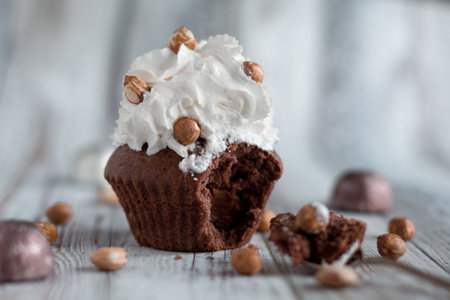 Delicious chocolate brownie muffins with nuts and whipped creamの写真素材