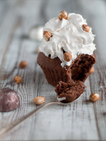 Delicious chocolate brownie muffins with nuts and whipped creamの写真素材