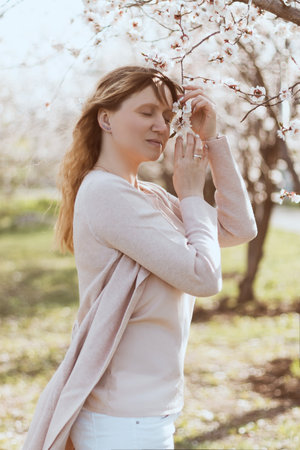 A girl relaxes near a flowering treeの写真素材