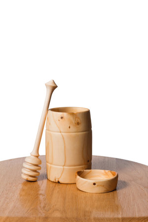 Eco-tableware in the form of jars, plates and spoons for honey made of wood on an isolated white background with a copy spaceの写真素材