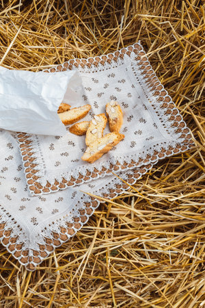 Almond cookies crackers with pieces of nuts lie on a napkin against the background of straw. A snack in natureの写真素材