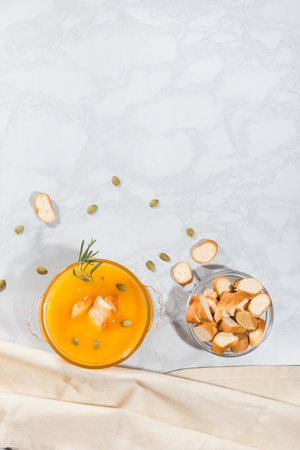 Pumpkin cream soup with crackers and seeds, top view, with copy space. Vegetarian lunchの写真素材
