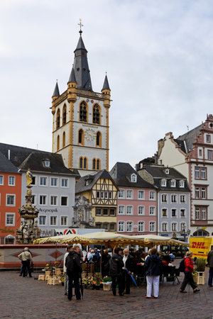 The ancient Market square in Trier city in Germany  Trier is the oldest city in Germany  The tower of St  Gangolf Church Is seen behind the houses のeditorial素材