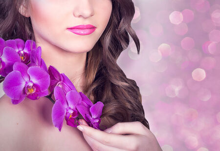 lower part of the face of a girl with orchidsの写真素材