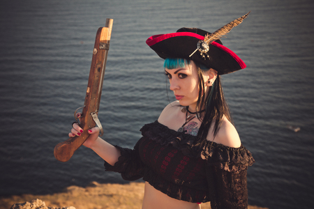 Portrait of a pirate woman at the beach. In anticipation of a pirate ship, sunsetの写真素材