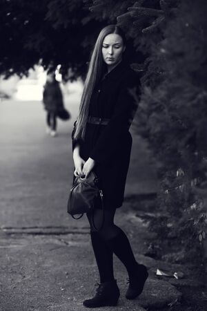 Walking young blonde woman. Black-white photo.