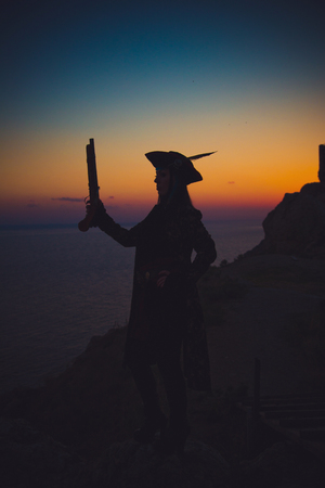 Portrait of a pirate woman at the beach. In anticipation of a pirate ship, sunsetの写真素材