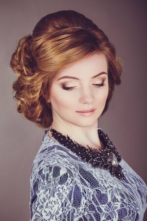 Studio photo of a young woman in retro style, evening dress and jewelry,
