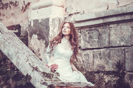 Portrait of young woman in the spring time. Almond flowers blossoms. Girl dressed in white like a...