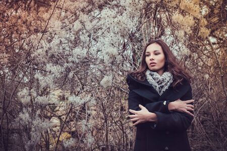 Fashion woman walking in dark autumn parkの写真素材