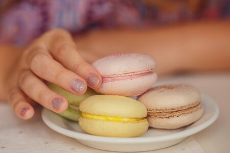 A lovely young girl with blond hair eating dessert and drinking tea in a cafe. the idea and concept of sweet life and pleasureの写真素材