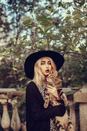 Outdoor lifestyle portrait of pretty young girl, wearing in hipster swag grunge style urban background. Retro vintage toned image, film simulation. Street walkの写真素材