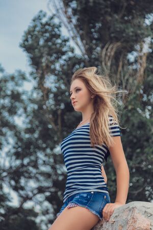 Travel tourism and people concept. Fashion blonde girl with blue heart shaped sunglasses in marina against yachts in portの写真素材