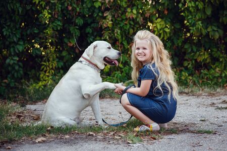Beautiful blonde girl playing with her dog. Outdoor portrait. series
