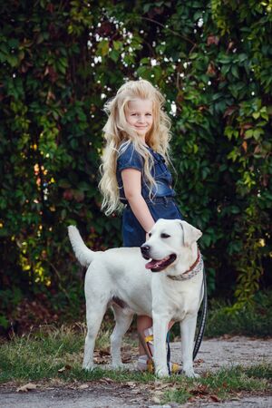 Beautiful blonde girl playing with her dog. Outdoor portrait. series