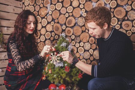 Christmas couple in a rural wooden house. Happy couple hugging. New Year & Christmas love story, studio photo shootの写真素材