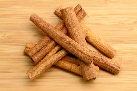 Stack of Cinnamon Sticks (On wood background)