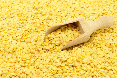 Yellow Lentils and wooden spoon closeup