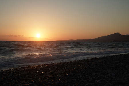 Sunset at sea. Mountains and seashore.の写真素材