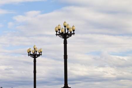 Streetlights against the blue sky and white cloudsの写真素材