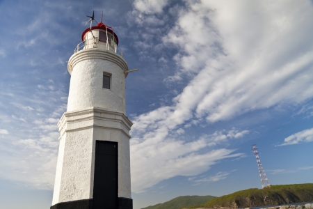 Lighthouse on the seashore in the solar morningの写真素材