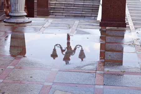 After a rain the lamp is reflected in a pool