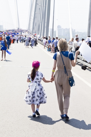 People celebrate city birthday, dance and walk on the bridge with children and tagsのeditorial素材